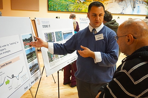 Presenter discussing images on a poster.
